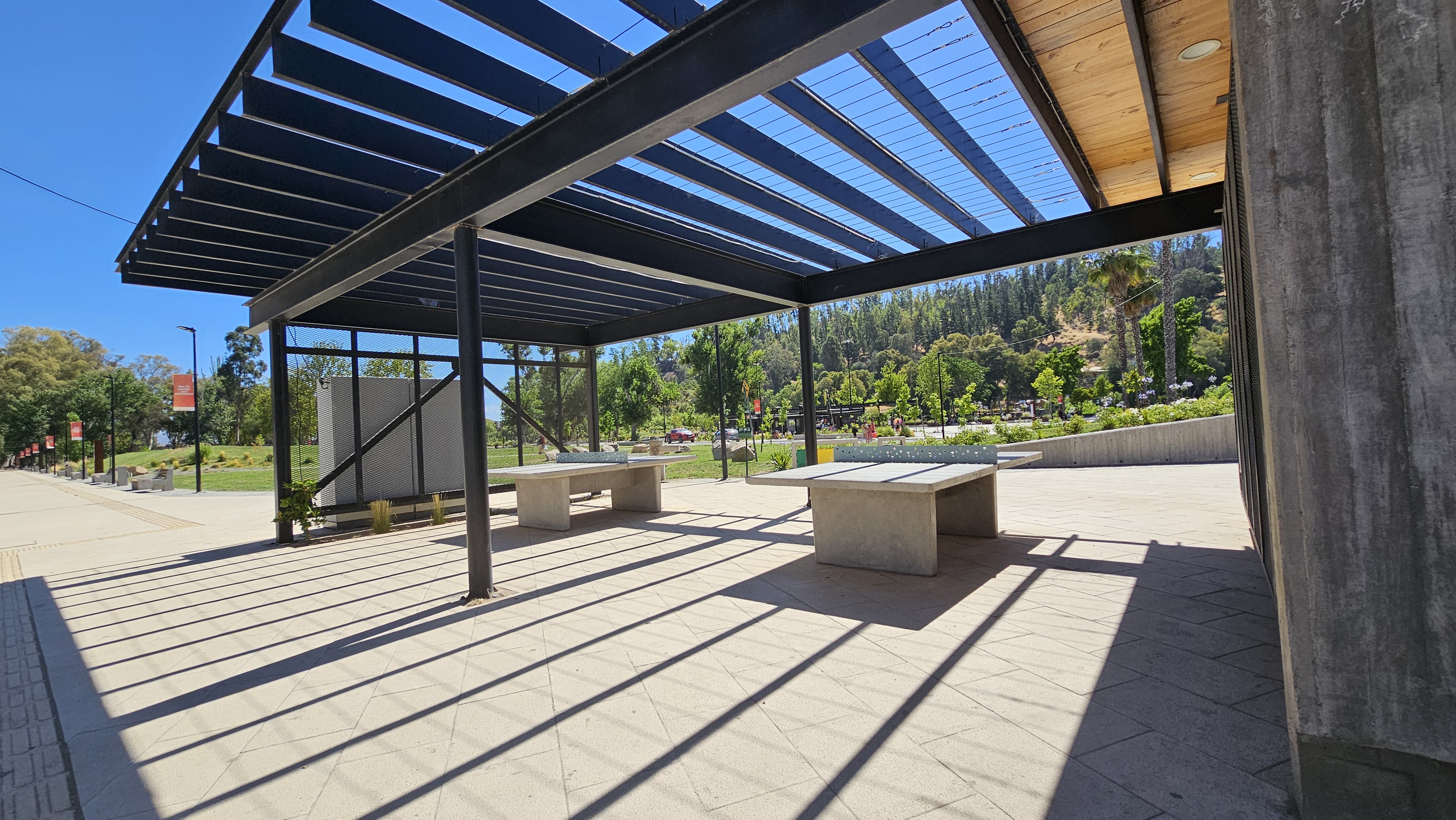 Fotografía de un sector del parque que cuenta con mesas fijas